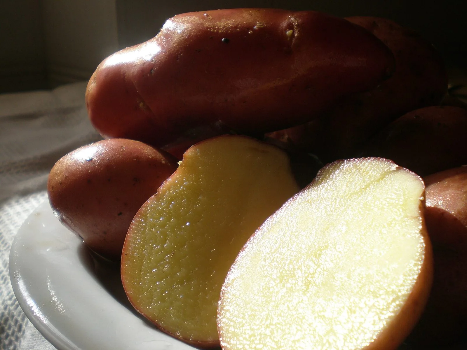 Patate rosse di Colfiorito tagliate a metà, con buccia rossa e polpa gialla